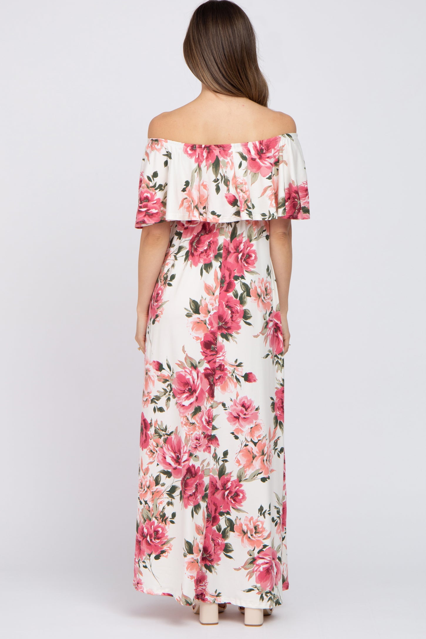 woman wearing a floral off-the-shoulder maternity maxi dress with a flowy design and a light background