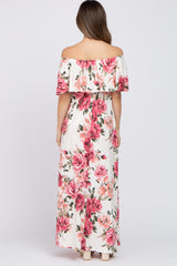 woman wearing a floral off-the-shoulder maternity maxi dress with a flowy design and a light background