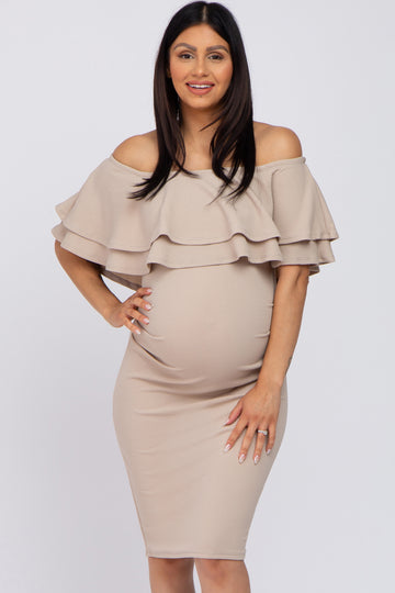 woman wearing a beige off-the-shoulder maternity dress with ruffle detail and showing her baby bump