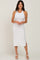 woman wearing a white ribbed midi dress with side slits and a fitted silhouette