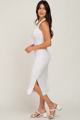 woman wearing a white ribbed midi dress with a side slit and styled with white heeled sandals