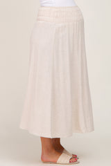woman wearing a beige linen midi skirt with an elastic waistband and woven slide sandals