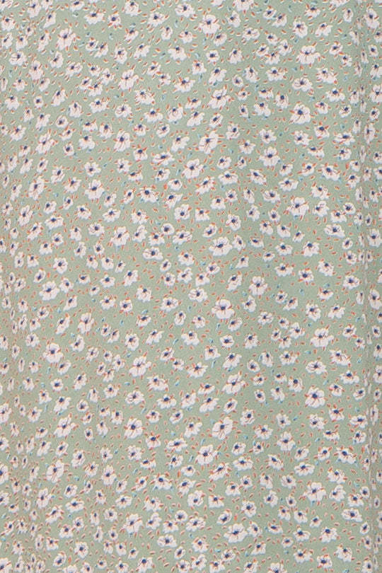 close up of sage green fabric with small white and blue floral ditsy print
