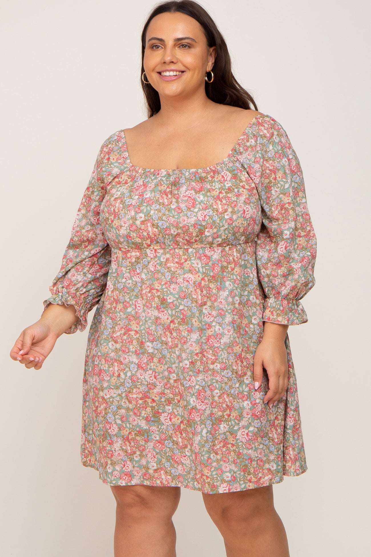 woman wearing a plus size floral print mini dress with square neckline and puff sleeves