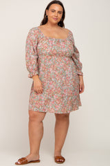 woman wearing a floral print plus size dress with long puff sleeves and a square neckline, standing and smiling