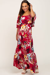 woman wearing a red floral off-shoulder maternity maxi dress with a tie waist and a visible baby bump
