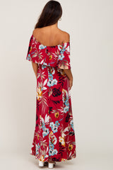 woman wearing a red floral off-shoulder maxi dress with a flowing ruffle overlay, shown from the back