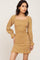 woman wearing a yellow floral long sleeve dress with a square neckline and ruffled hemline