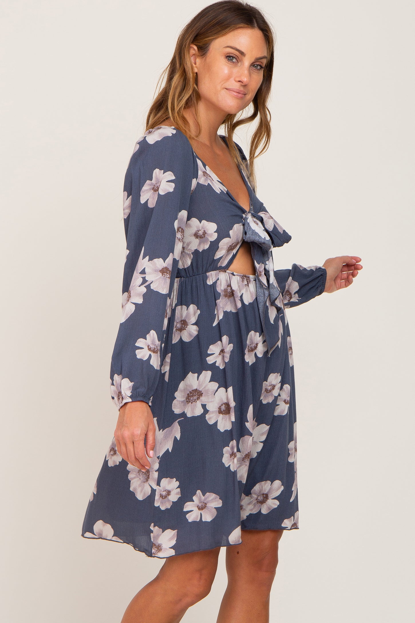 woman wearing a navy floral dress with a tied front and cut-out details