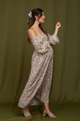 woman wearing a floral off-the-shoulder maternity maxi dress with puff sleeves and a visible baby bump