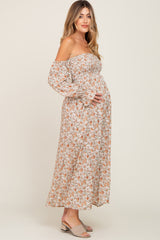 woman wearing a floral off-the-shoulder maternity dress with a baby bump visible
