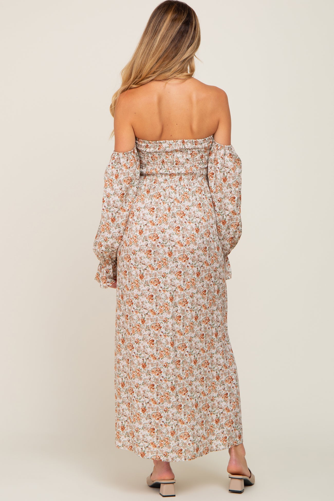 woman wearing a floral off-the-shoulder maternity maxi dress with long sleeves, showing a relaxed fit and back detail