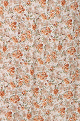 maternity wear floral fabric with orange and beige roses on a light background