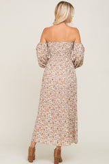 woman wearing a floral off-the-shoulder maxi dress with puffed sleeves and a fitted bodice, seen from the back