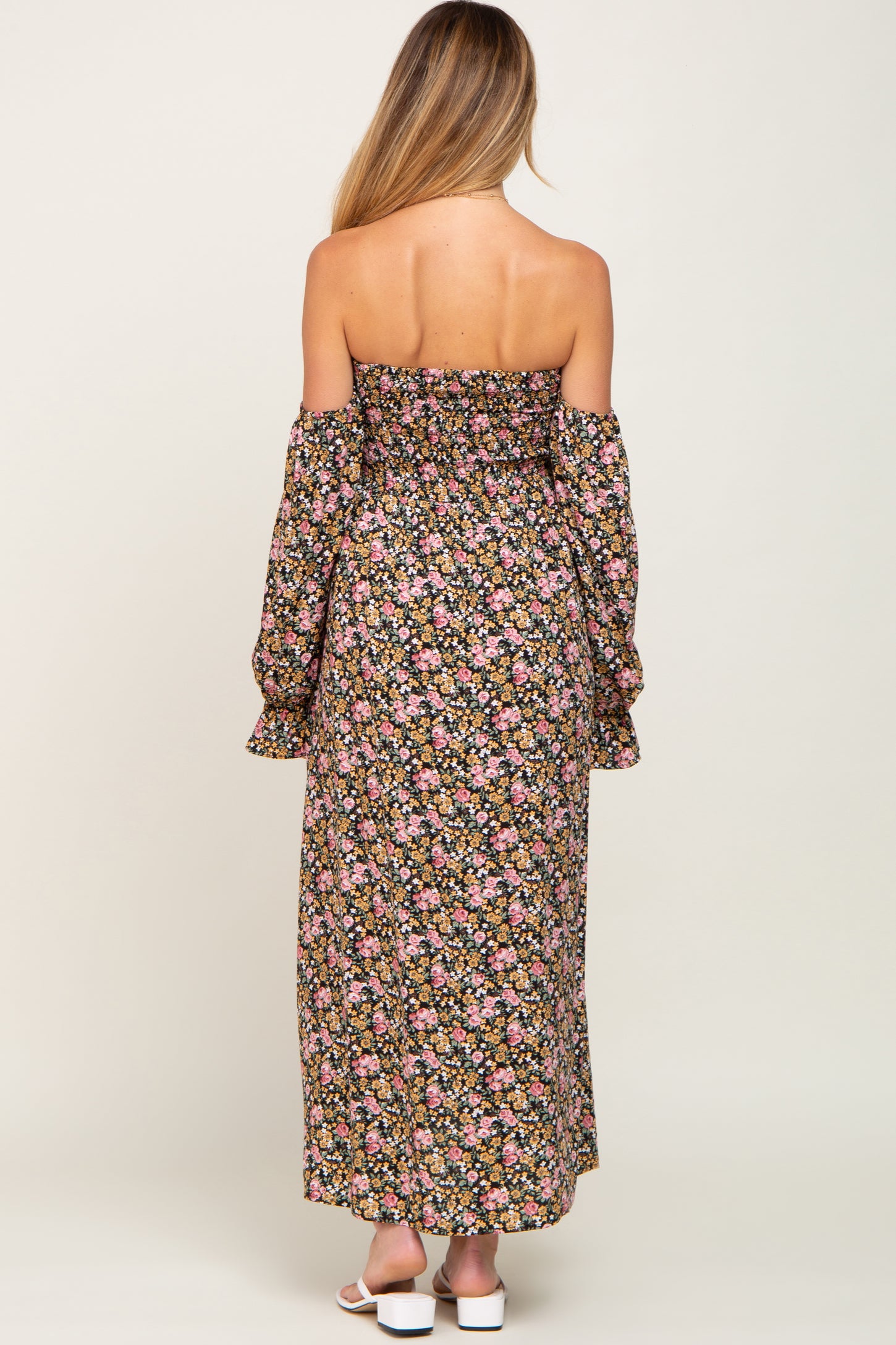 woman wearing a floral off-the-shoulder maternity maxi dress with bell sleeves and a fitted bodice