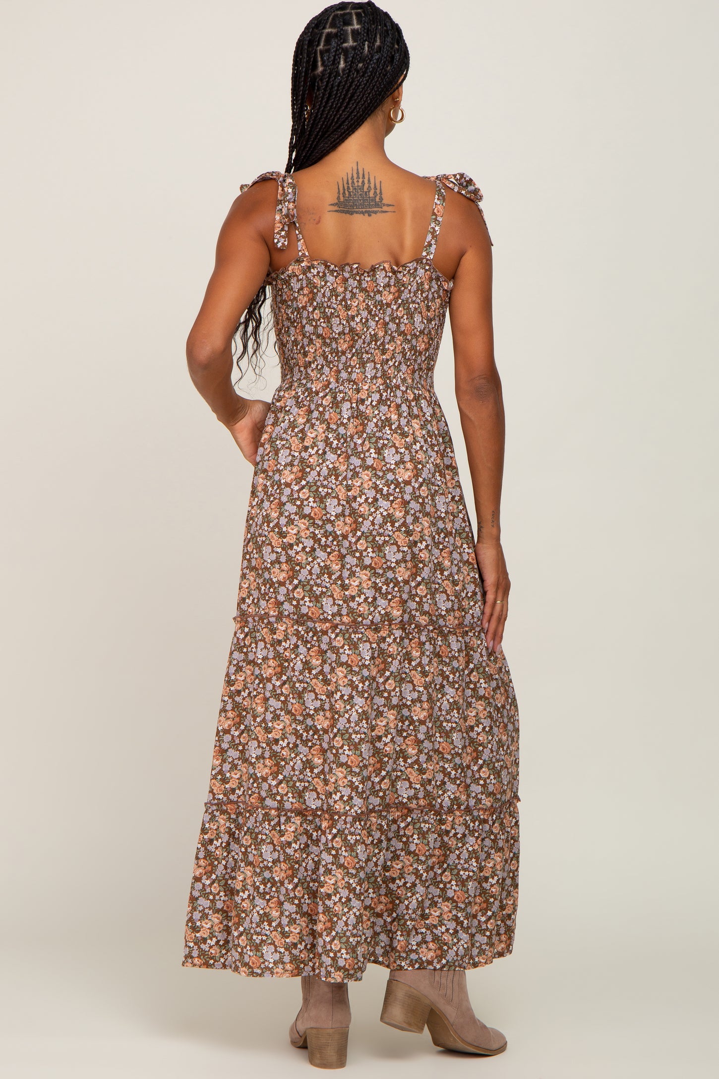 woman wearing a brown floral maxi dress with ruffled straps and a smocked back view