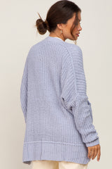 Woman wearing a light blue oversized chunky knit cardigan sweater from the back