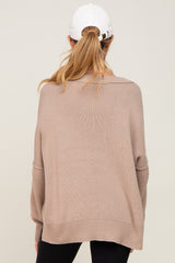 woman wearing a tan oversized maternity sweater with a relaxed fit and long sleeves, seen from the back