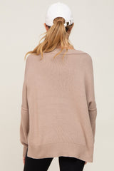 woman wearing a tan oversized maternity sweater with a relaxed fit and long sleeves, seen from the back