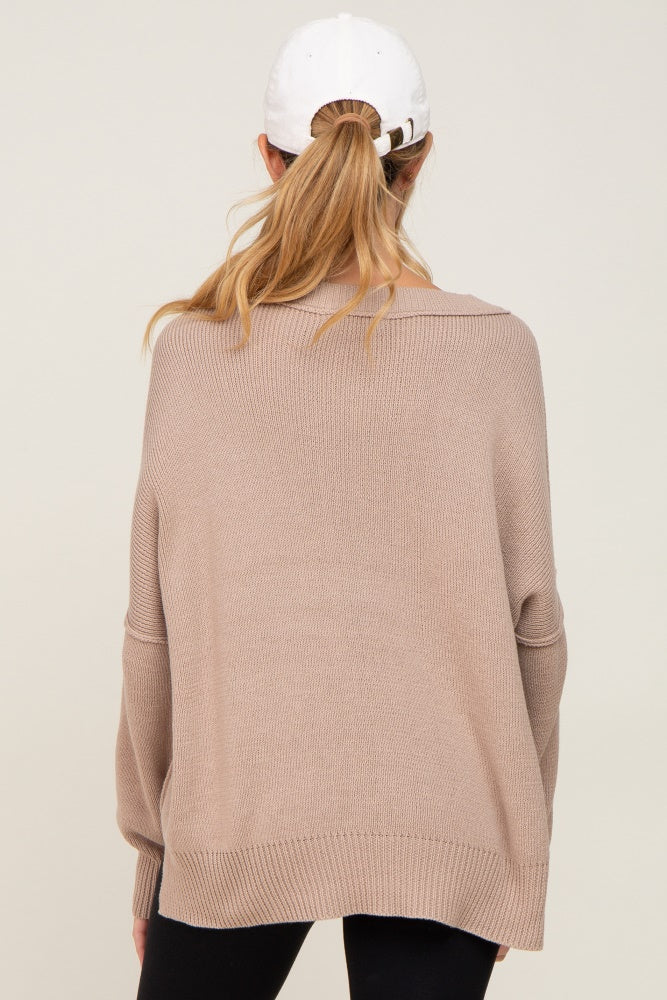 woman wearing a tan oversized maternity sweater with a relaxed fit and long sleeves, seen from the back