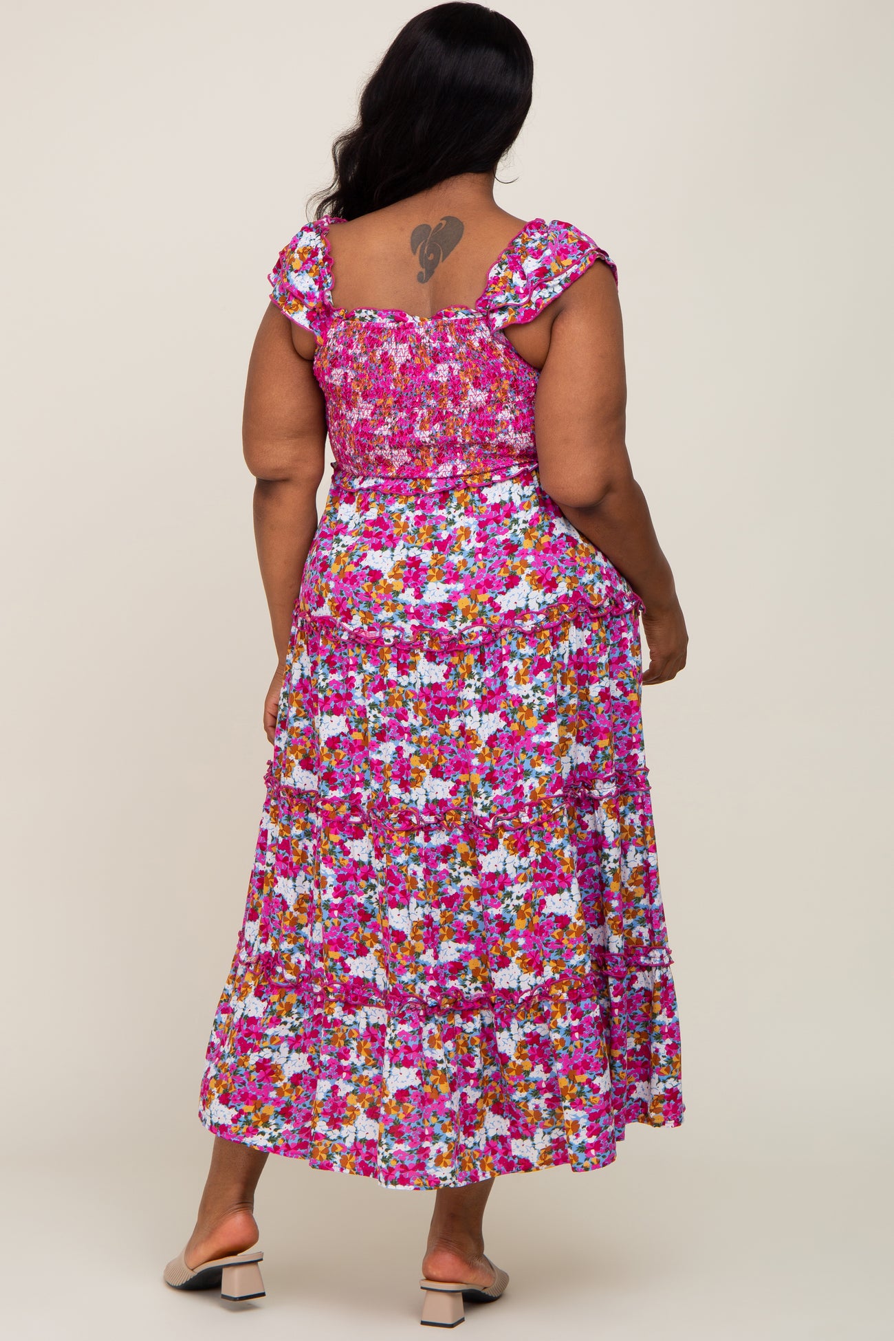 plus size woman wearing a floral maxi dress with a smocked bodice and tiered skirt, showing the back view
