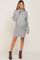woman wearing a gray oversized knitted maternity dress with a cowl neck and long sleeves, showing her baby bump