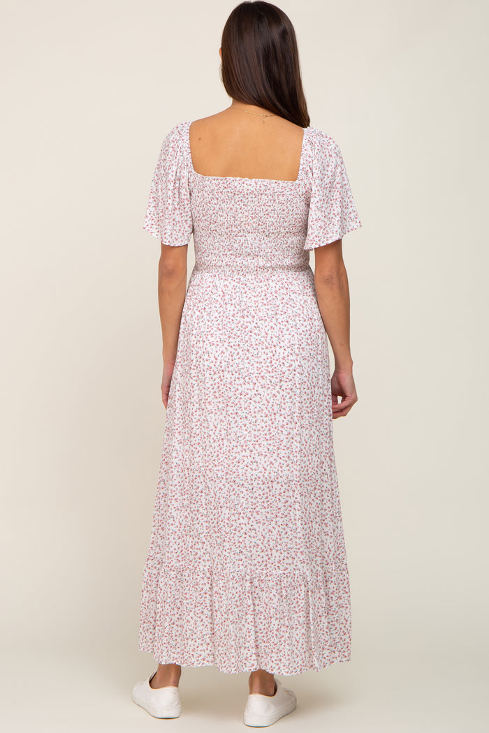 back view of woman wearing white floral smocked maxi dress with short puff sleeves and square neckline