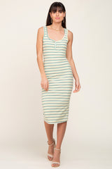 woman wearing a striped midi tank dress in green and cream with a front button detail and strappy sandals