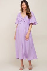 pregnant woman in lavender swiss dot maternity midi dress with tie front and flutter sleeves