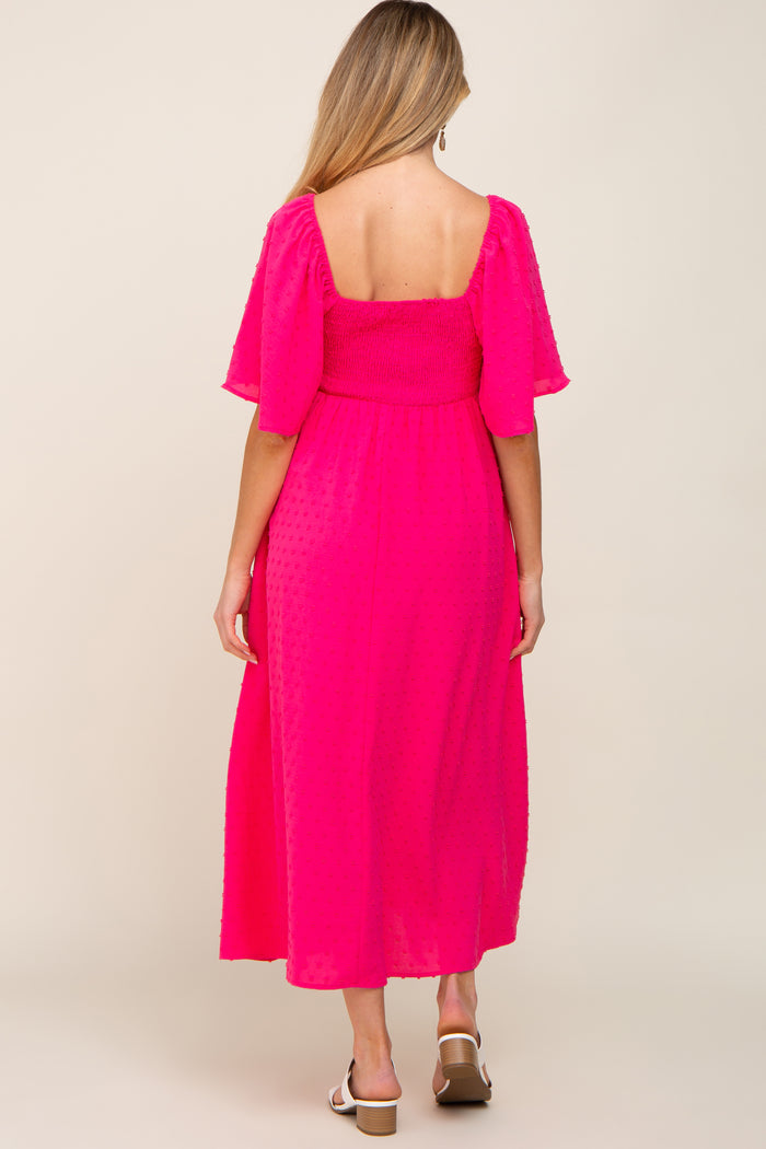 woman wearing a hot pink maternity maxi dress with flutter sleeves and a fitted bodice, showing her baby bump from the back