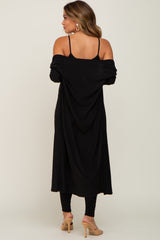 woman wearing a black off-the-shoulder maternity dress with thin straps and a flowing design