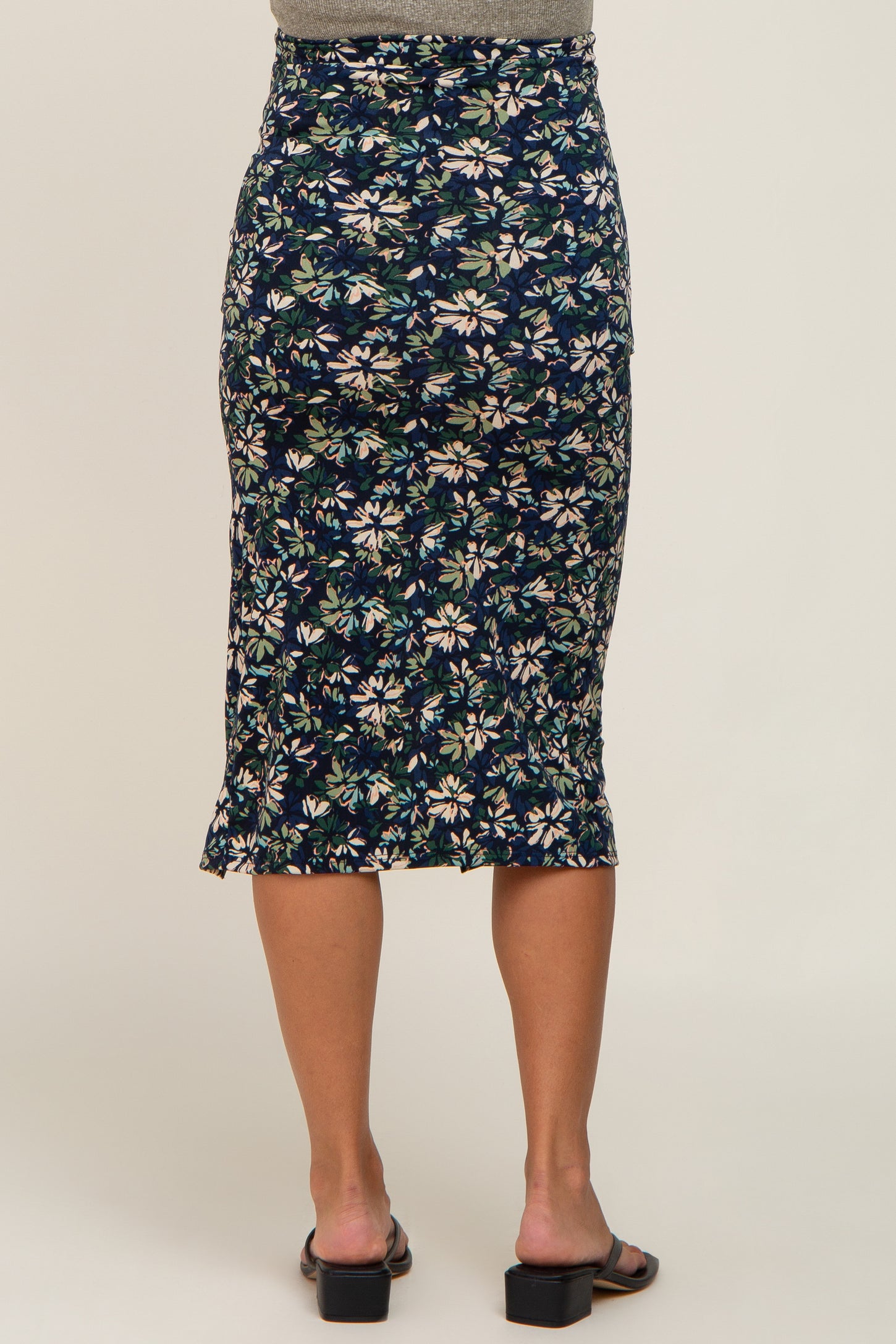 woman wearing a navy floral maternity pencil skirt, showing a fitted silhouette and knee-length style from the back