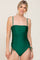 blonde woman wearing an emerald green ruched one-piece swimsuit with spaghetti straps and side ties