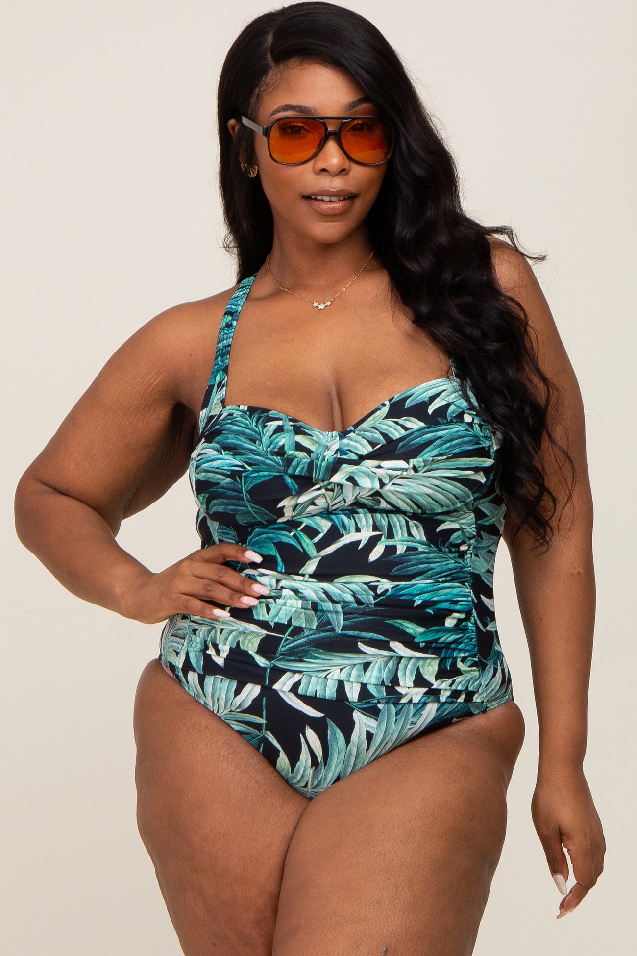 woman wearing a tropical print plus size swimsuit with a sweetheart neckline and thick straps, posing confidently