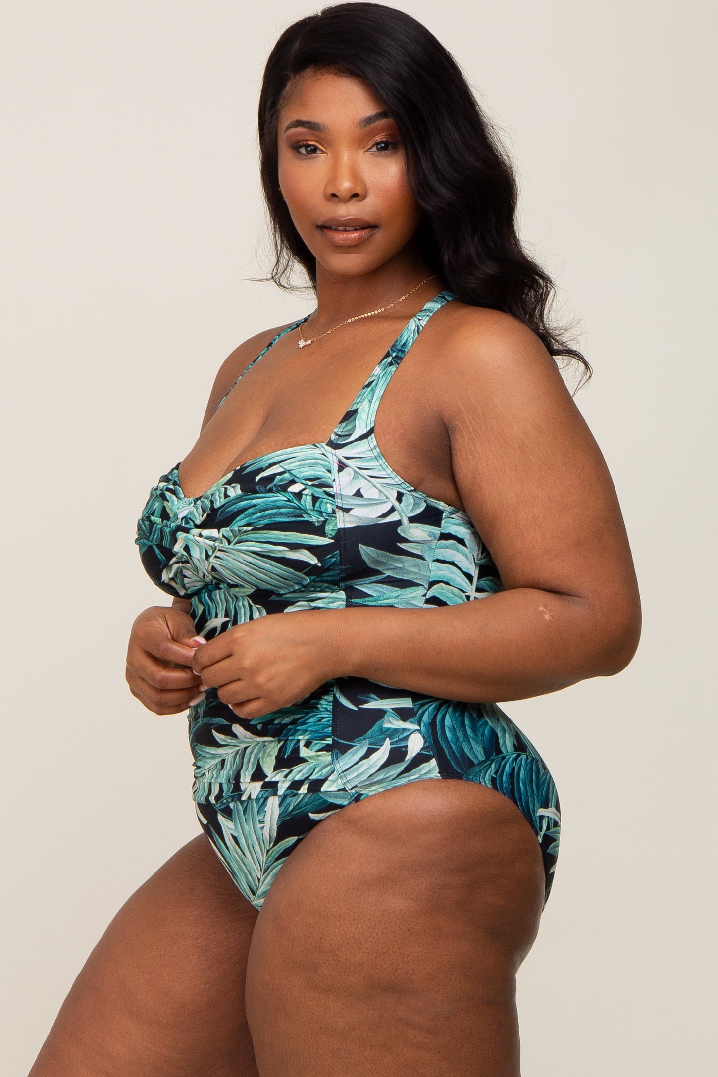 woman wearing a plus size tropical print one-piece swimsuit with ruffle detail and adjustable straps
