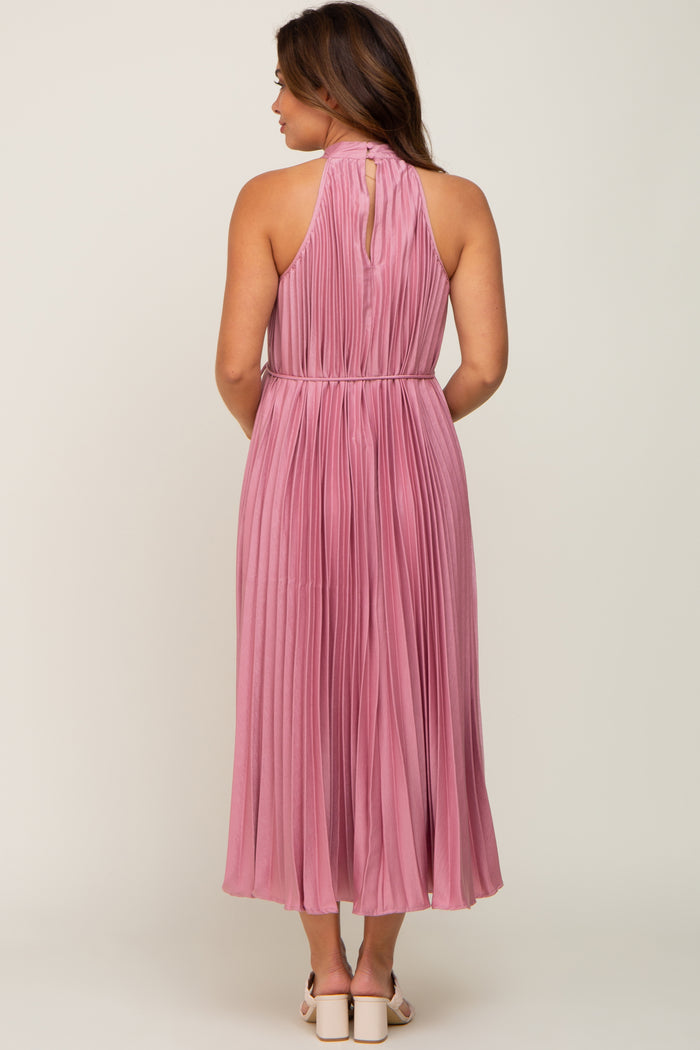 maternity wear long pink pleated dress with a halter neck and a keyhole back detail, model facing away from the camera