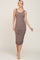 woman wearing a taupe sleeveless ruched midi dress with a scoop neckline and a bodycon fit