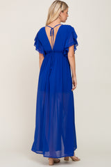 woman wearing a blue maxi dress with ruffled sleeves and an open back, viewed from the back