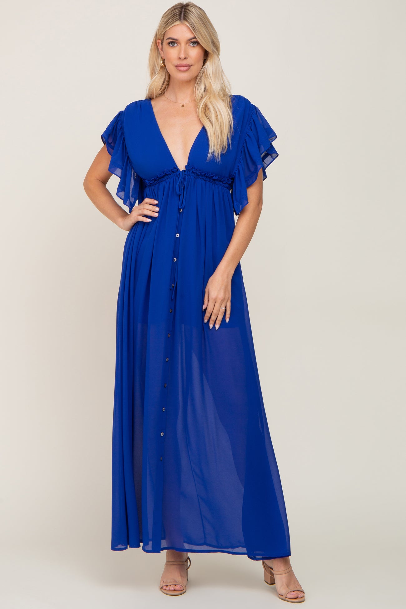 woman wearing a blue maxi dress with flutter sleeves and a deep v-neck, featuring a button-down front
