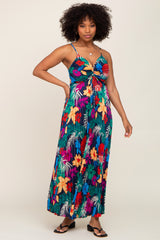 woman wearing a vibrant floral maxi dress with thin straps and a twist front detail