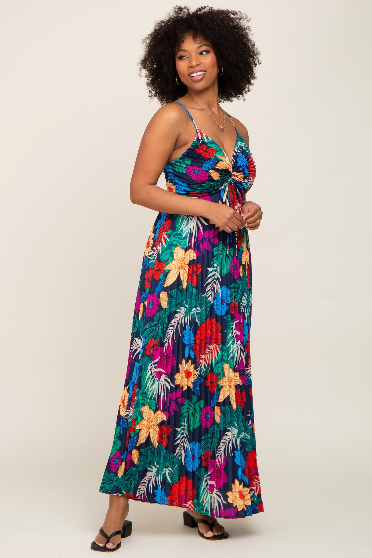 woman wearing a colorful floral maxi dress with a tie front and spaghetti straps
