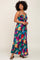 woman wearing a colorful floral maxi dress with a tie front and spaghetti straps