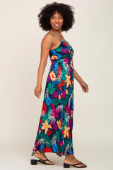 woman wearing a colorful floral maxi dress with spaghetti straps and a fitted bodice