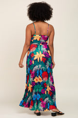 woman wearing a colorful floral maxi dress with spaghetti straps, showing the back view and flowing fabric