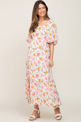 woman wearing a floral print maternity maxi dress with puff sleeves and a square neckline, showing her baby bump