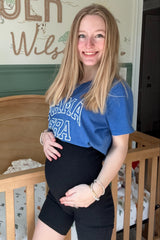 woman wearing a blue graphic maternity t-shirt and black maternity shorts, showing her baby bump