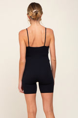 woman wearing a black maternity bodysuit with thin straps and shorts style, showing the back view