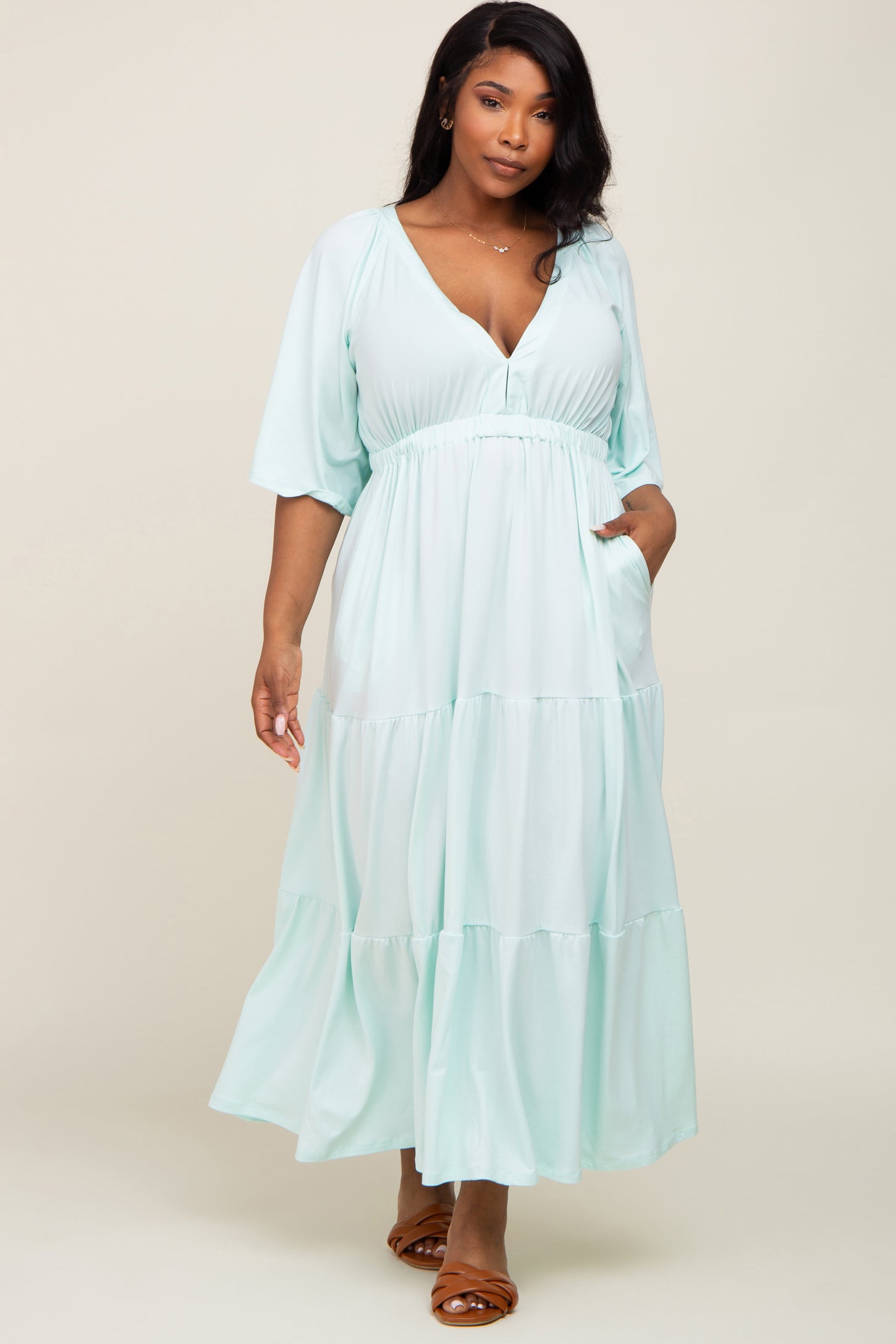 Woman wearing a light blue tiered maxi dress with short sleeves and a v-neckline