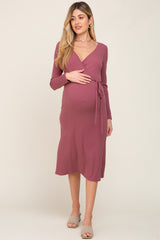 woman wearing a mauve long sleeve wrap maternity dress with a tie waist and visible baby bump