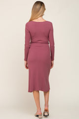woman wearing a long sleeve mauve maternity dress, showing the back view and a fitted silhouette